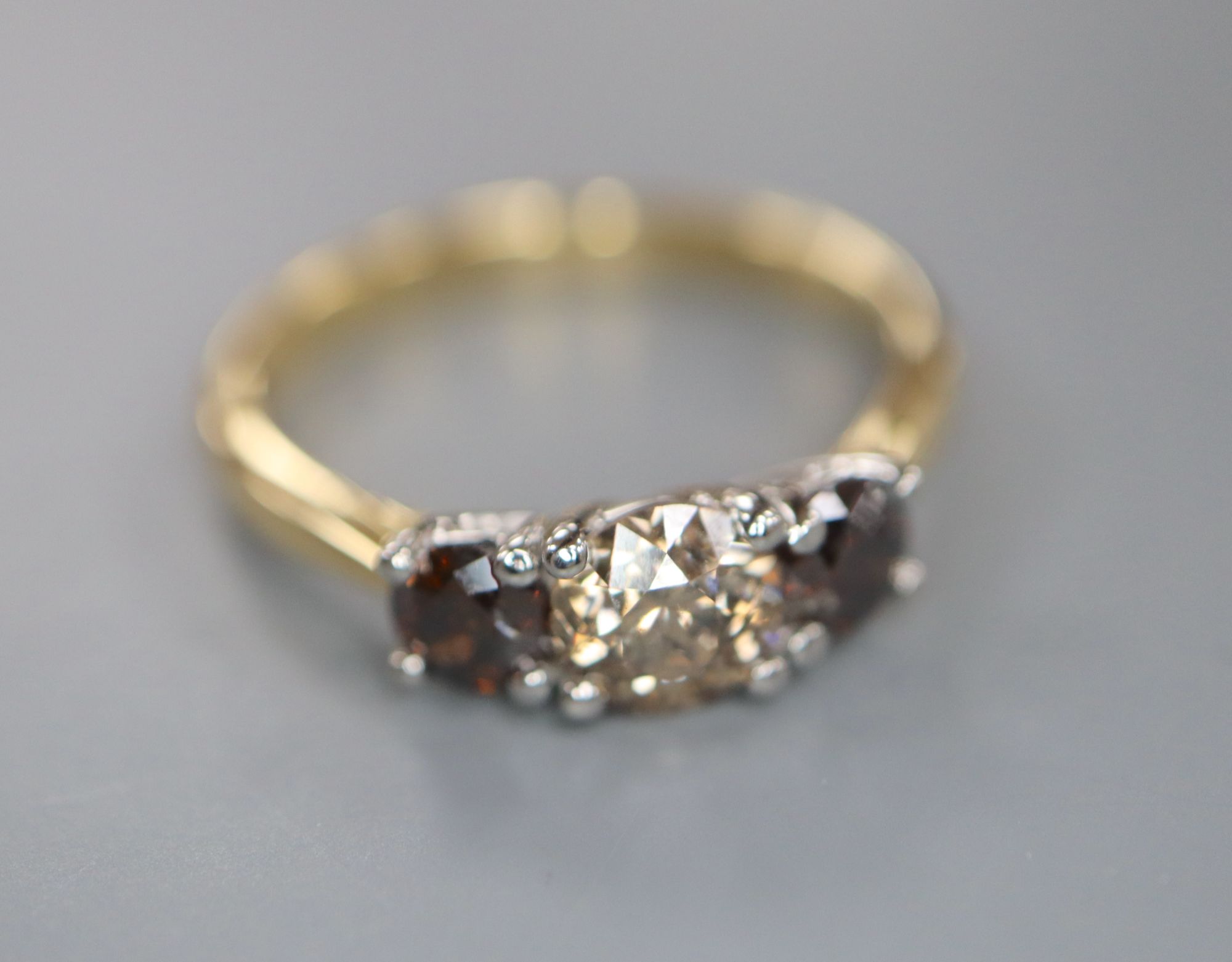 A modern 18ct gold and platinum, three stone two colour diamond set ring, size M, gross weight 3.5 grams.